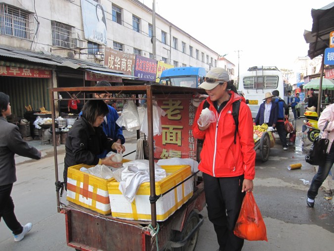 Fanny eating "mantou" (a kind a bread bun) from a hawker in the main town